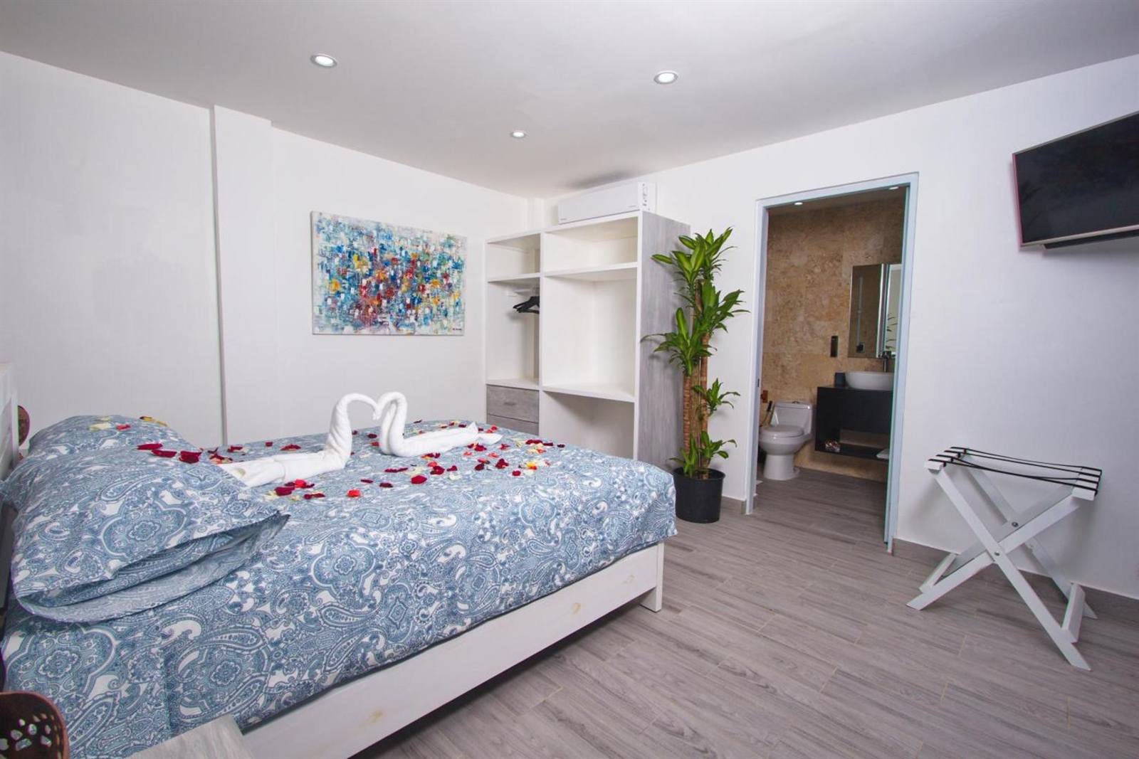 La Aldea 124: room with a double bed, a plant and access to the bathroom