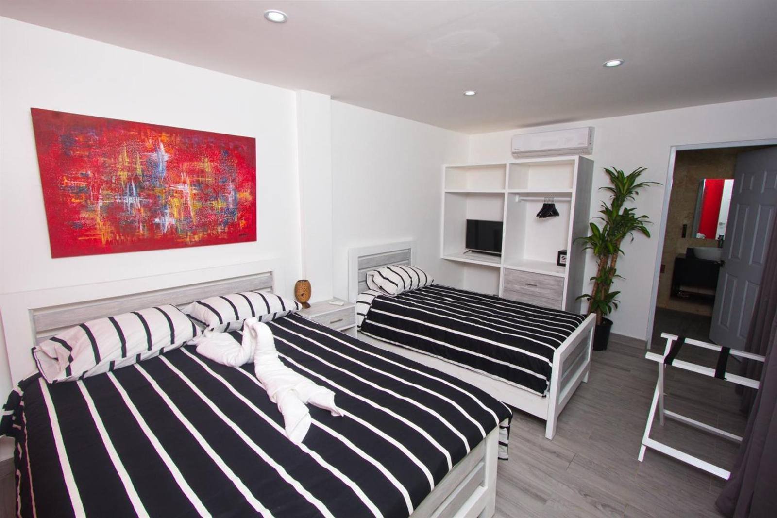 La Aldea 124: room with two beds and a red painting on the wall