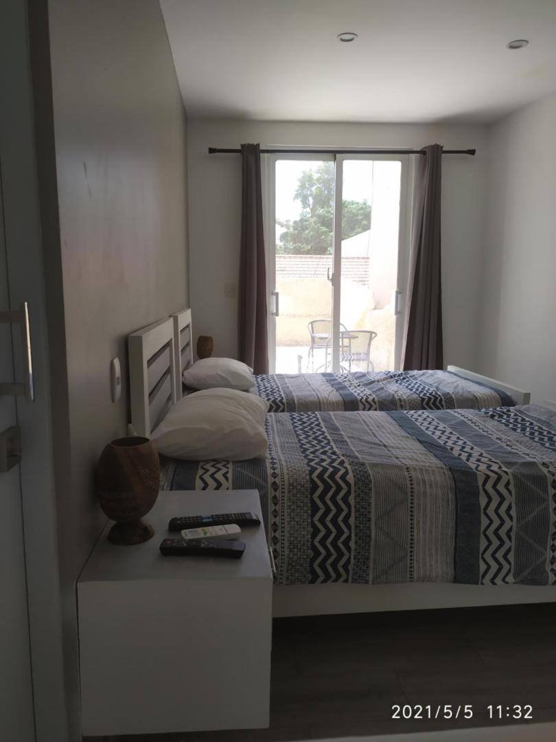 La Aldea 124: bright room with a window and two beds
