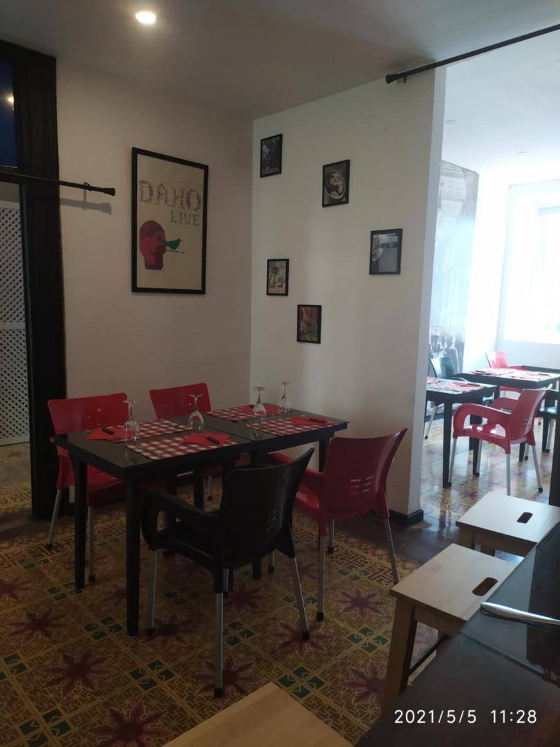 La Aldea 124: bistro dining room with tables and red chairs