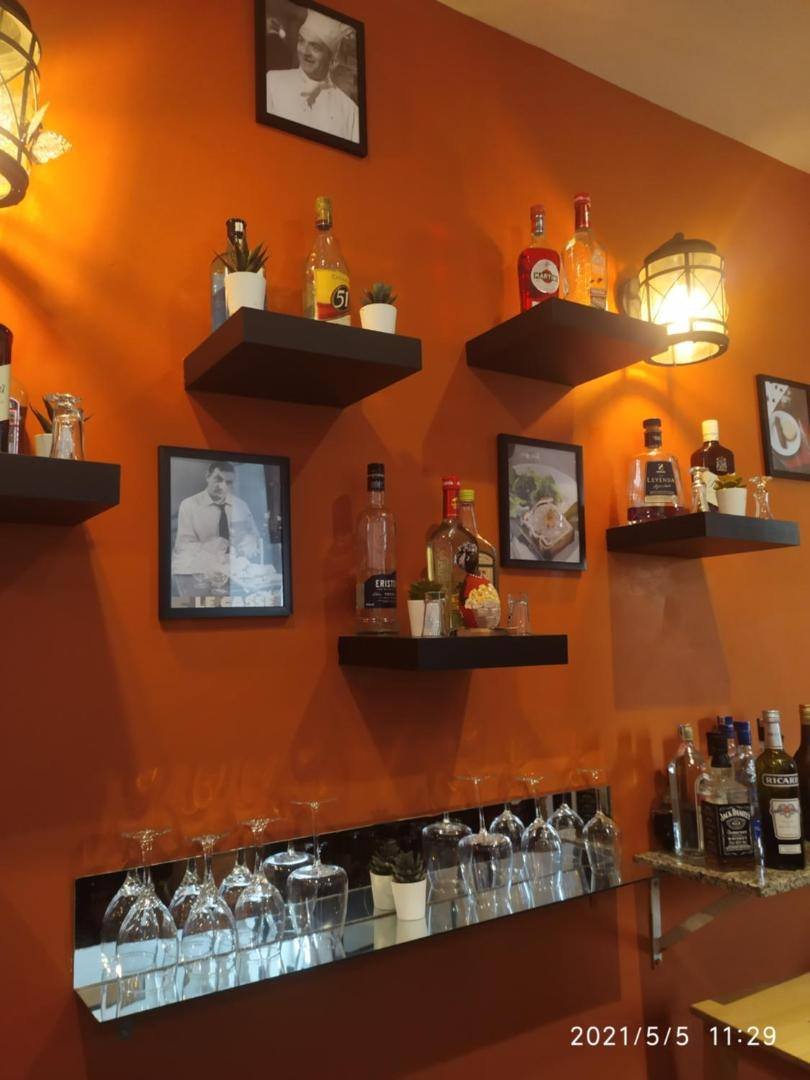 La Aldea 124: bar with an orange wall and shelves of bottles